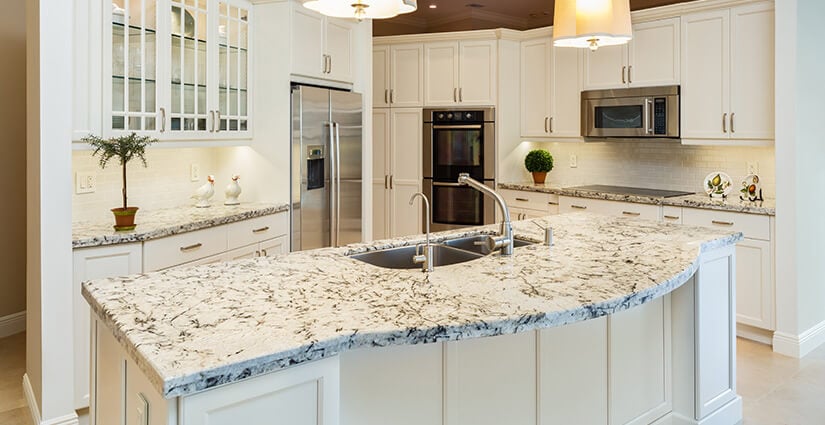 Kitchen with white cabinets and black and white epoxy countertops replicating natural stone.