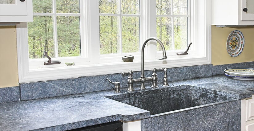Blue slate kitchen countertop with integrated farmhouse sink.