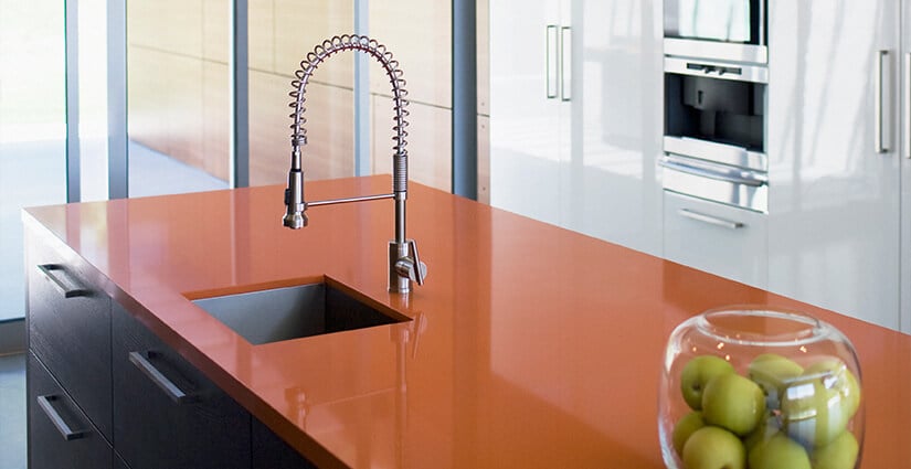 Rust red high-gloss polyester countertop with modern stainless steel sink.