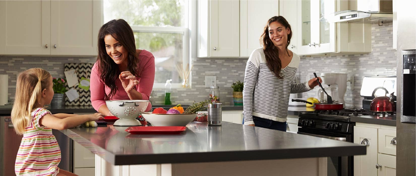 Image of 3 women around a kitchen island.