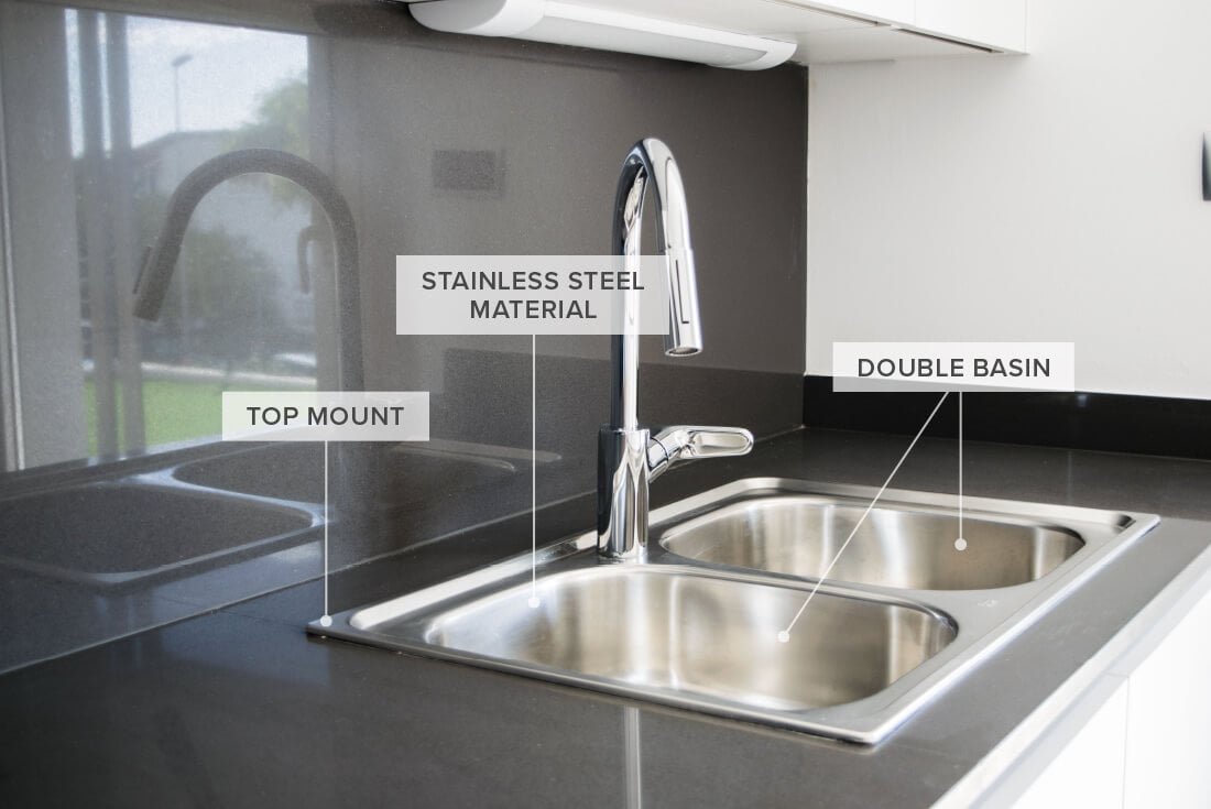 Stainless steel sink installed on black granite countertop with matching backsplash.