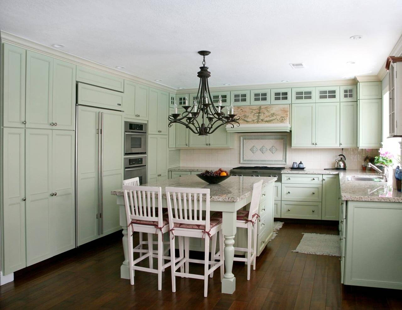 A u-shaped country-style kitchen with mint-painted cabinets.