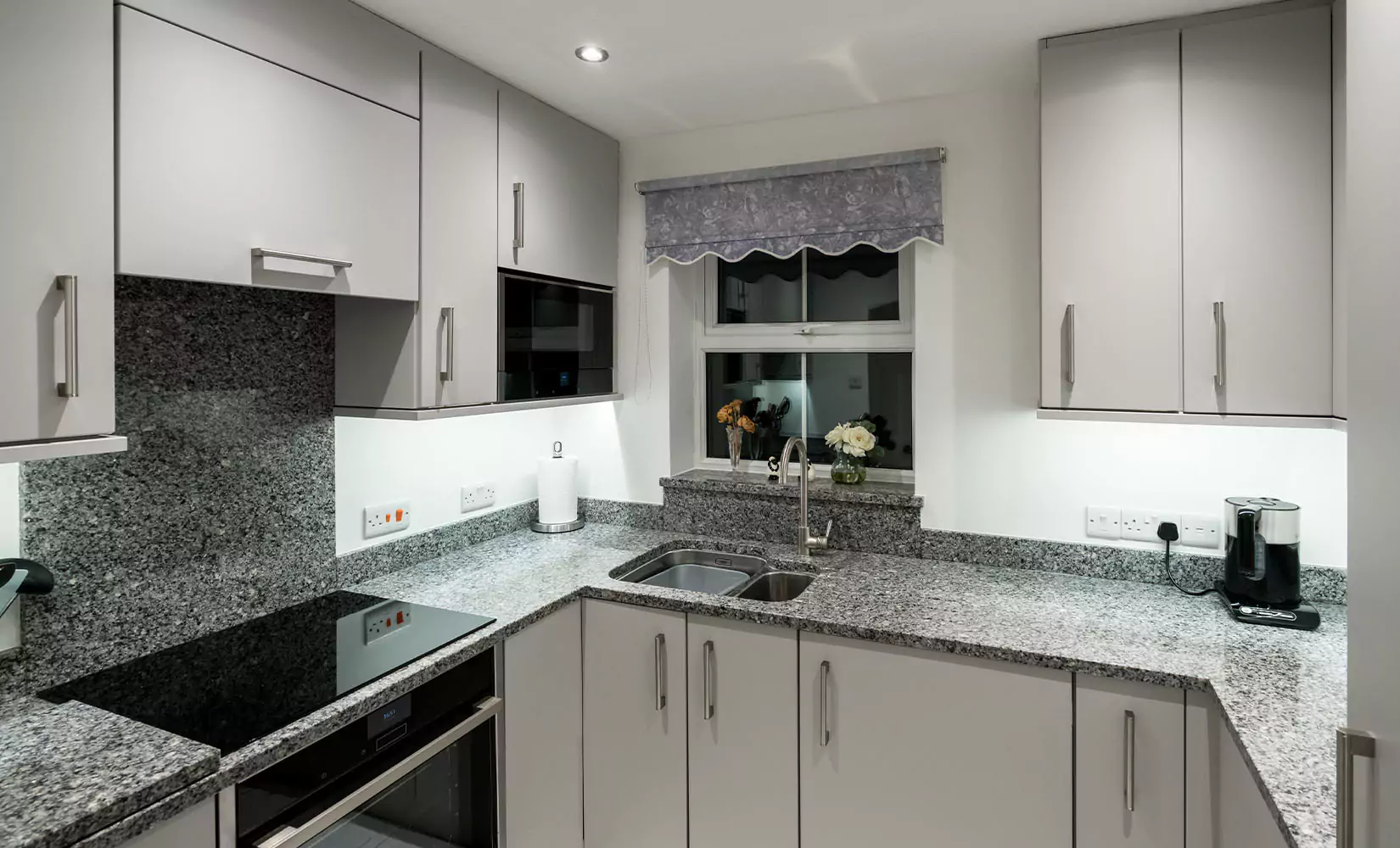 Small U-shaped kitchen with sink near stovetop.