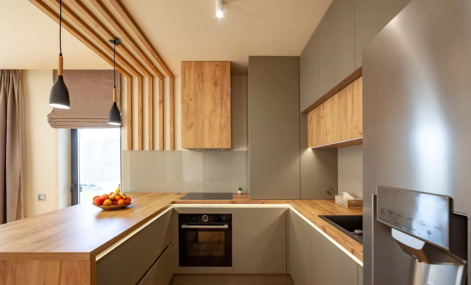 Modern u shaped kitchen with ceiling accents separating it from dining room.