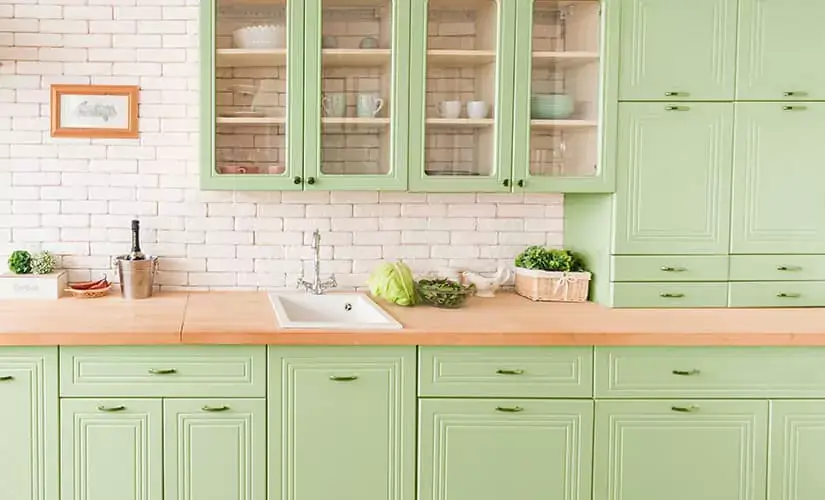 Kitchen with green painted cabinets.