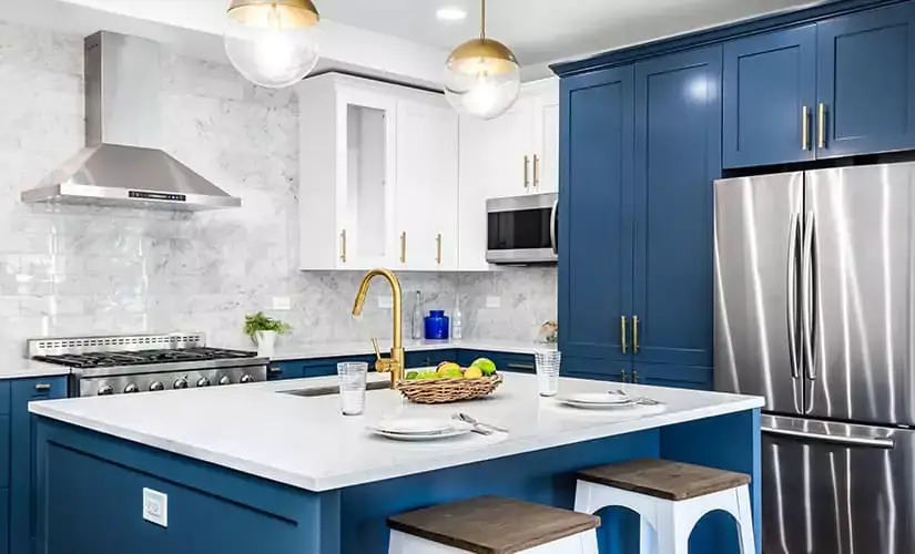 Kitchen with two tone white and blue cabinets.